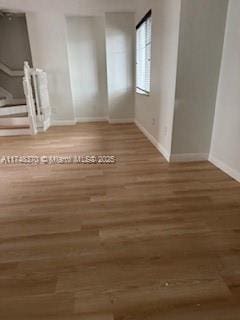 empty room featuring wood finished floors and baseboards