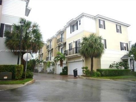 view of property with aphalt driveway and an attached garage