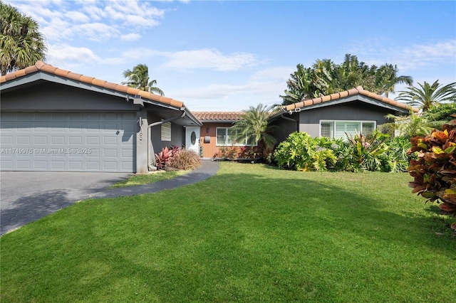 ranch-style home with a front yard, driveway, a tiled roof, and an attached garage