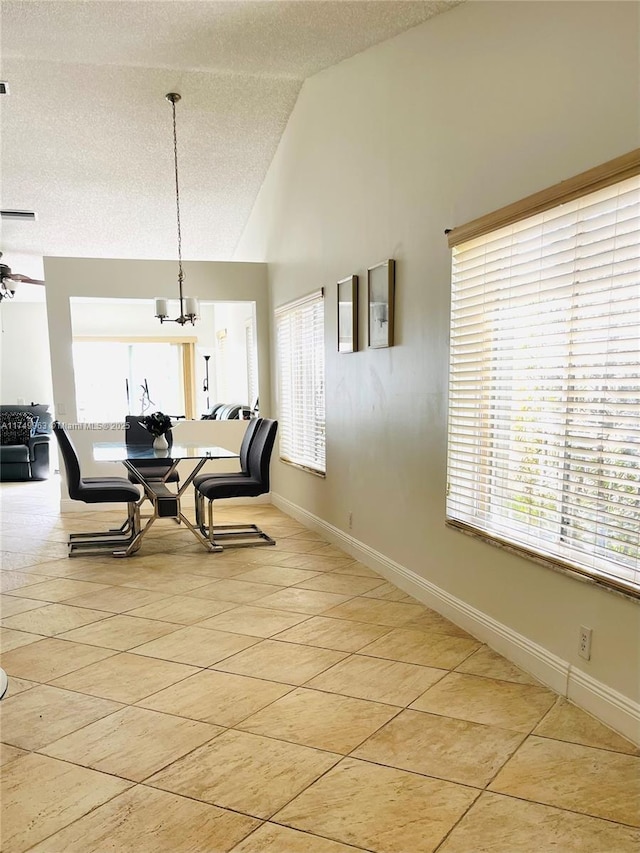 dining room featuring light tile patterned floors, an inviting chandelier, a textured ceiling, high vaulted ceiling, and baseboards