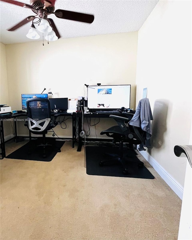 carpeted office featuring ceiling fan, a textured ceiling, and baseboards