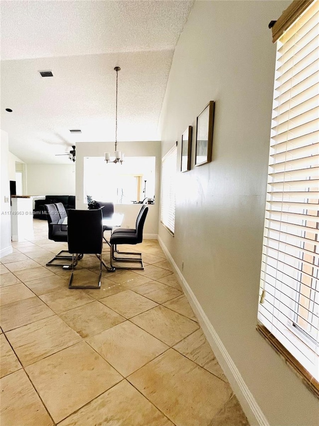 dining room with visible vents, a textured ceiling, baseboards, and light tile patterned floors