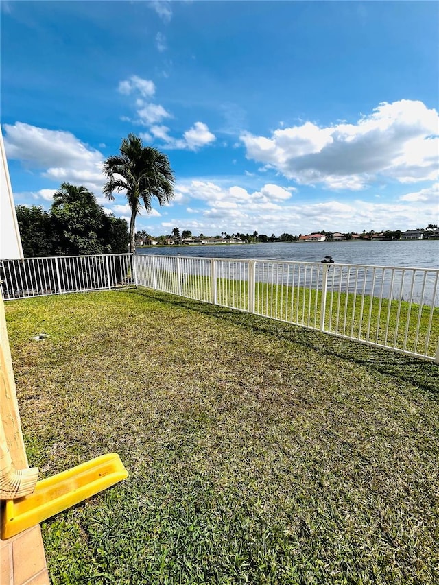 view of yard with a water view and a fenced backyard