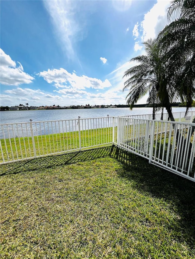 view of yard featuring a water view and fence