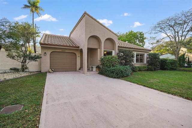 mediterranean / spanish-style house with stucco siding, concrete driveway, an attached garage, a tiled roof, and a front lawn