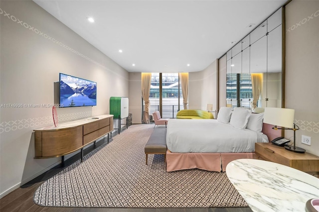 bedroom featuring expansive windows, baseboards, wood finished floors, and recessed lighting