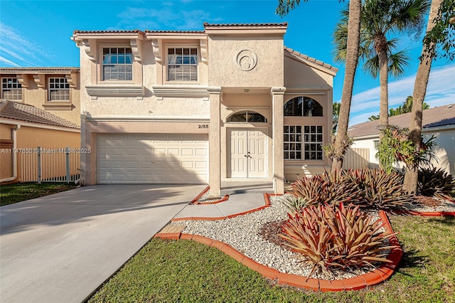 mediterranean / spanish house featuring an attached garage, fence, a tile roof, concrete driveway, and stucco siding