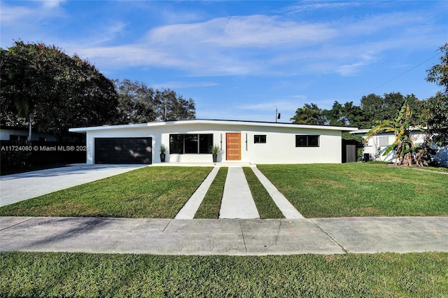 view of front facade featuring driveway, a front lawn, an attached garage, and stucco siding