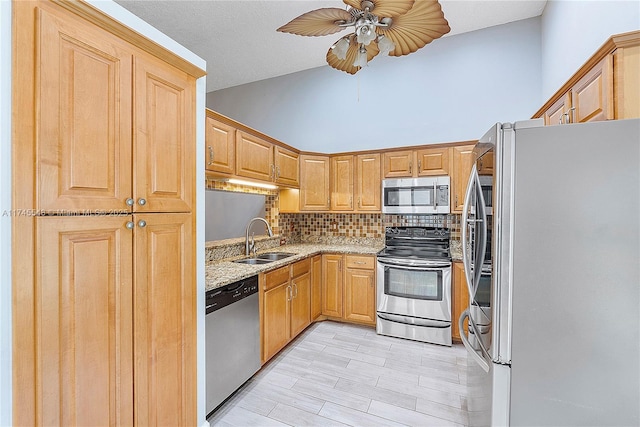 kitchen featuring tasteful backsplash, appliances with stainless steel finishes, a sink, ceiling fan, and high vaulted ceiling