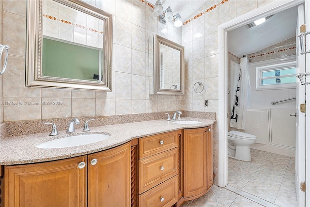 full bath featuring shower / bath combo with shower curtain, a sink, tile walls, and tile patterned floors