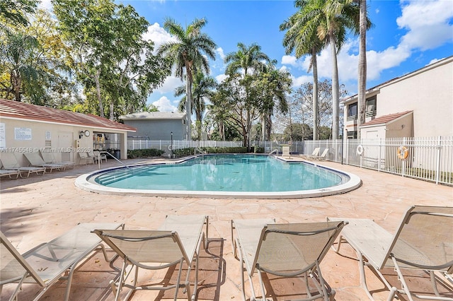 pool with fence and a patio