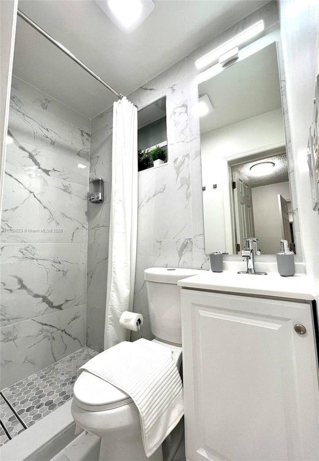 full bathroom featuring a shower stall, toilet, and vanity