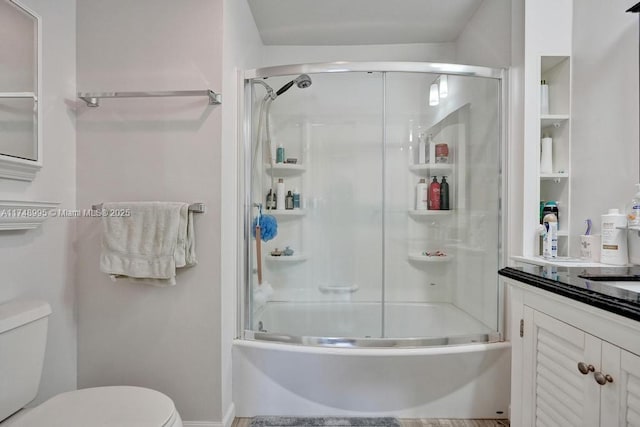 full bath featuring toilet, enclosed tub / shower combo, and vanity