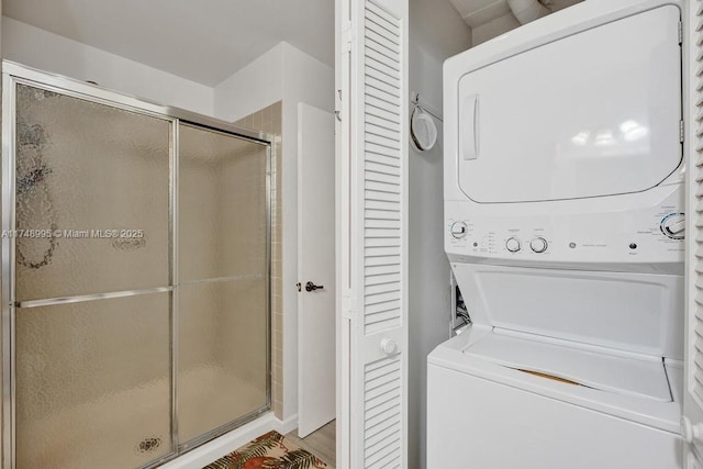 clothes washing area featuring stacked washing maching and dryer and laundry area