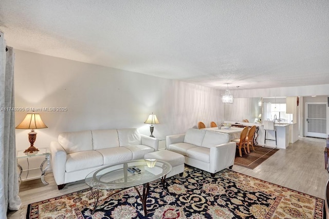 living area with light wood-style floors and a textured ceiling