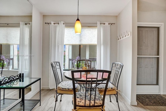 dining room featuring light wood-style flooring and baseboards