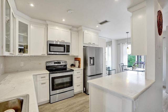 kitchen featuring stainless steel appliances, white cabinetry, glass insert cabinets, and visible vents