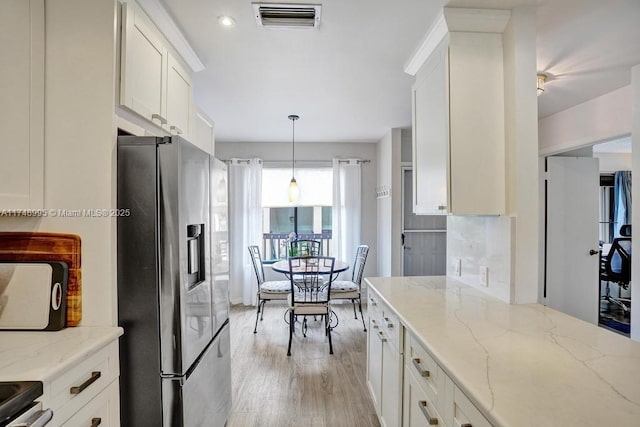 kitchen featuring visible vents, white cabinets, light stone countertops, and stainless steel fridge with ice dispenser