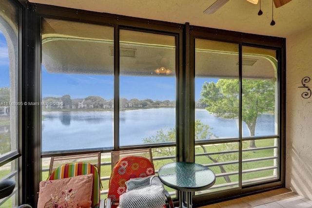 sunroom / solarium with a water view and ceiling fan