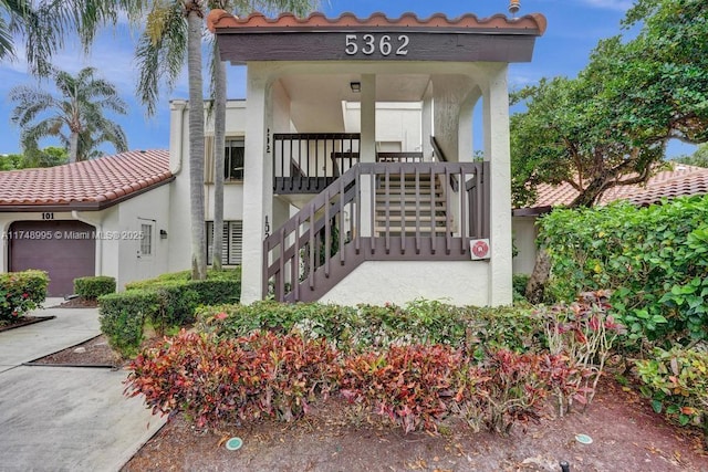 exterior space featuring a tiled roof and stucco siding