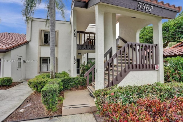 entrance to property featuring a tile roof and stucco siding