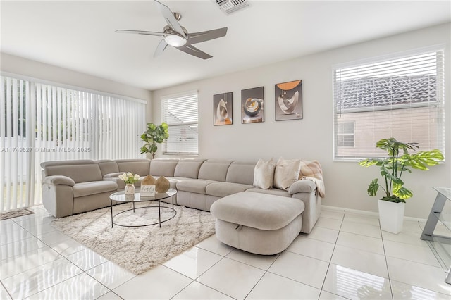 living area featuring baseboards, visible vents, ceiling fan, and light tile patterned flooring