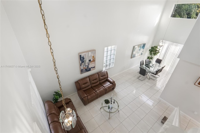 living area featuring a towering ceiling and light tile patterned floors