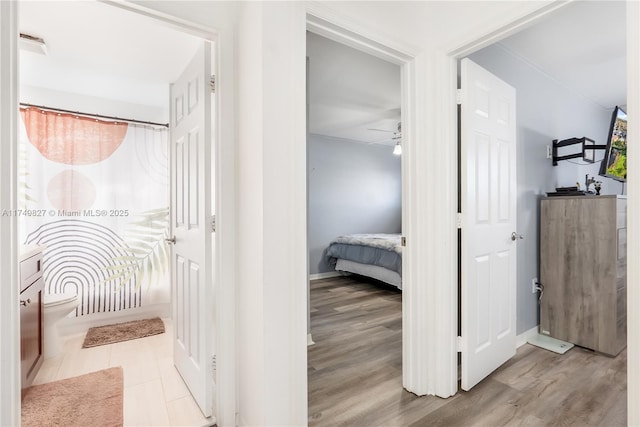 hall with light wood-type flooring and baseboards