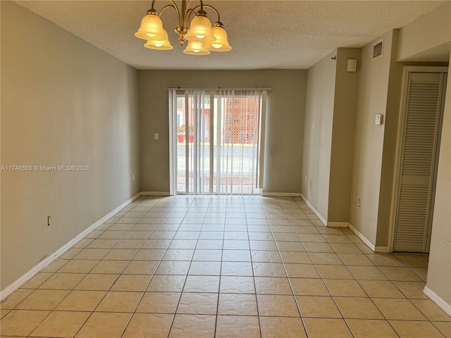 empty room featuring light tile patterned floors, visible vents, a textured ceiling, and an inviting chandelier