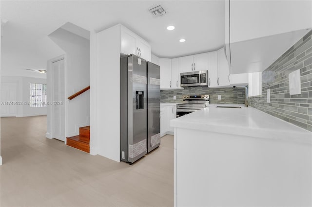 9745 NW 37th St Unit 9745, Sunrise, FL 33351 - kitchen with decorative backsplash, visible vents, appliances with stainless steel finishes, a sink, and white cabinets