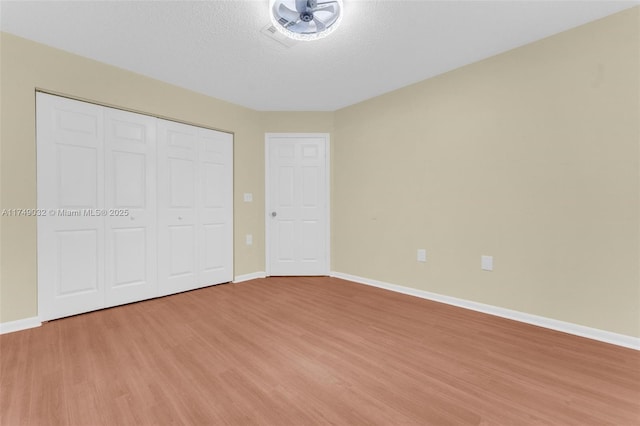 9745 NW 37th St Unit 9745, Sunrise, FL 33351 - unfurnished bedroom featuring baseboards, a closet, light wood-type flooring, and a textured ceiling
