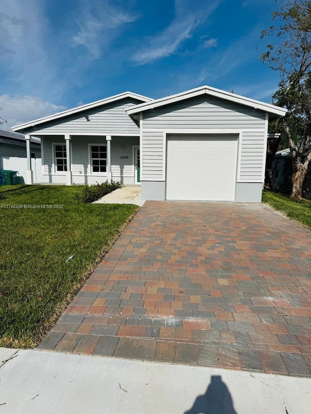 view of front of house with a garage, a front yard, and decorative driveway