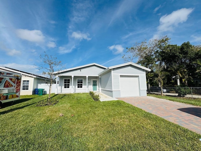 view of front of house featuring a garage, decorative driveway, a front yard, and fence