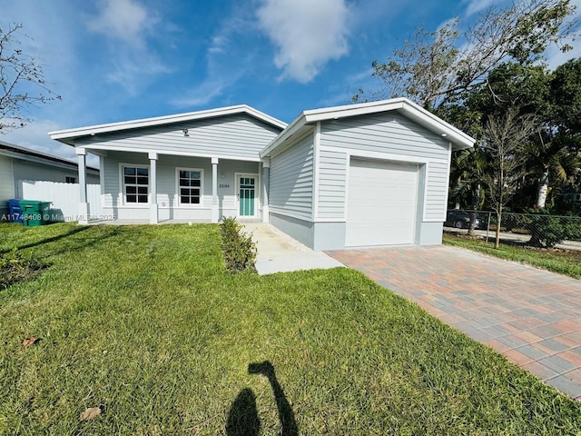 ranch-style home featuring a porch, a garage, fence, decorative driveway, and a front lawn