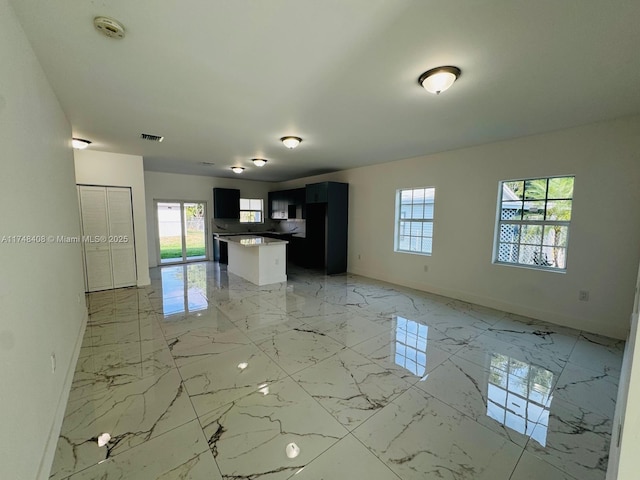 kitchen featuring open floor plan, marble finish floor, plenty of natural light, and light countertops