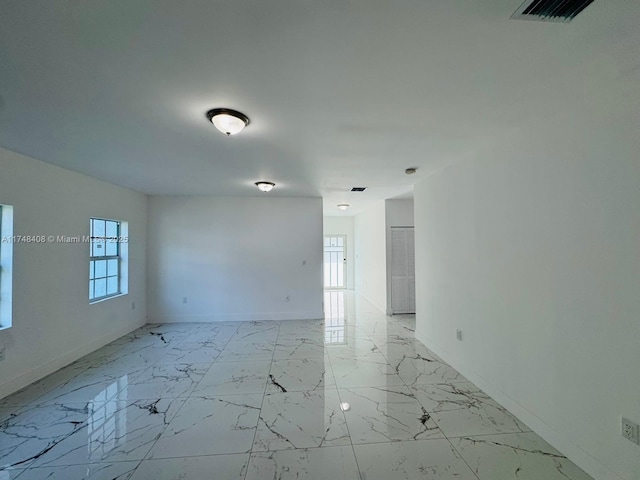 unfurnished room featuring marble finish floor, visible vents, and baseboards