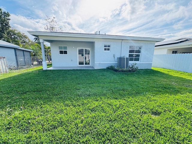 back of property featuring cooling unit, fence, a yard, stucco siding, and a patio area