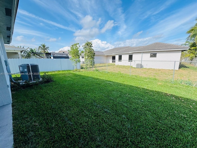 view of yard featuring central AC and a fenced backyard