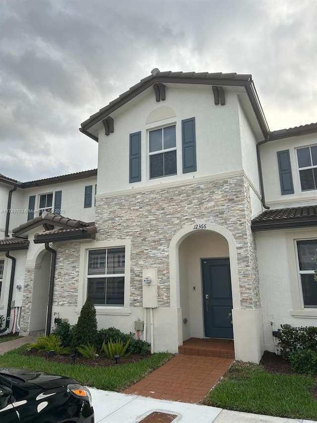 view of front of home featuring stone siding and stucco siding