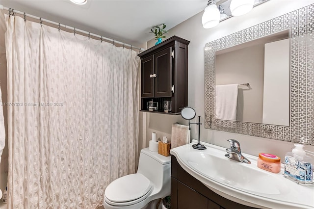 bathroom with curtained shower, vanity, and toilet