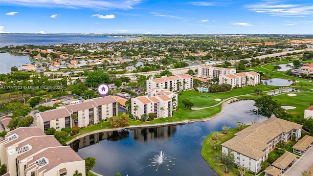 drone / aerial view featuring golf course view and a water view