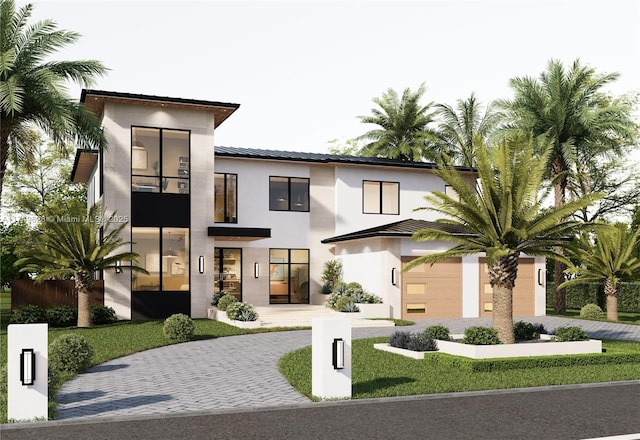 contemporary house with metal roof, decorative driveway, and stucco siding