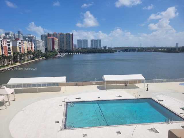 pool with a patio, a water view, and a city view