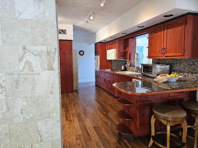 kitchen with dark wood-style floors, decorative backsplash, open shelves, and a sink