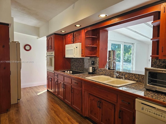 kitchen featuring dark wood-style floors, open shelves, tasteful backsplash, a sink, and white appliances