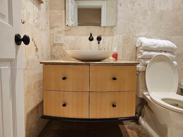 half bathroom with toilet, tile walls, and vanity