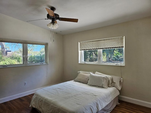 bedroom featuring a ceiling fan, baseboards, and wood finished floors