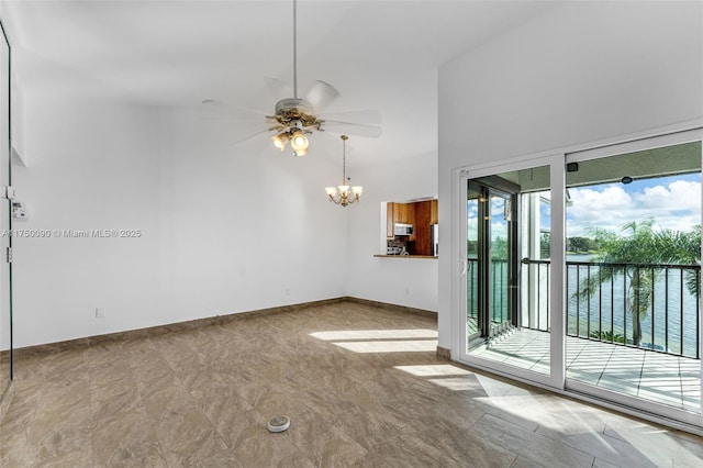 spare room with a water view, a high ceiling, baseboards, and ceiling fan with notable chandelier