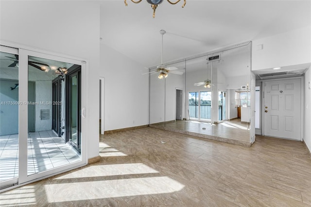 unfurnished living room with high vaulted ceiling, visible vents, ceiling fan, and baseboards