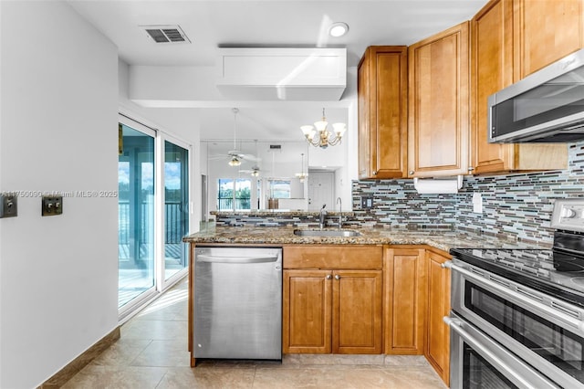 kitchen featuring visible vents, stone countertops, tasteful backsplash, a sink, and appliances with stainless steel finishes